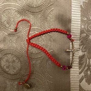 Pink bracelet with a cross on it